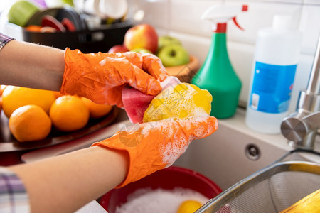 在厨房里用水肥皂或洗涤剂清水果